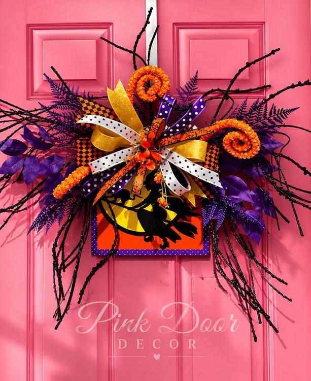 Witch silhouette Halloween swag with layered ribbons and black branches on the pink door