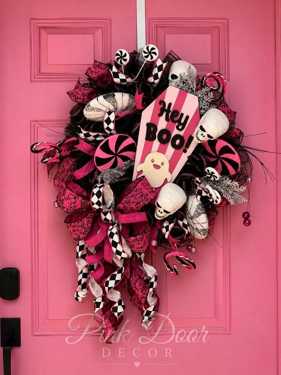 Hot pink and black Hey Boo wreath with skulls and peppermint accents on the pink door