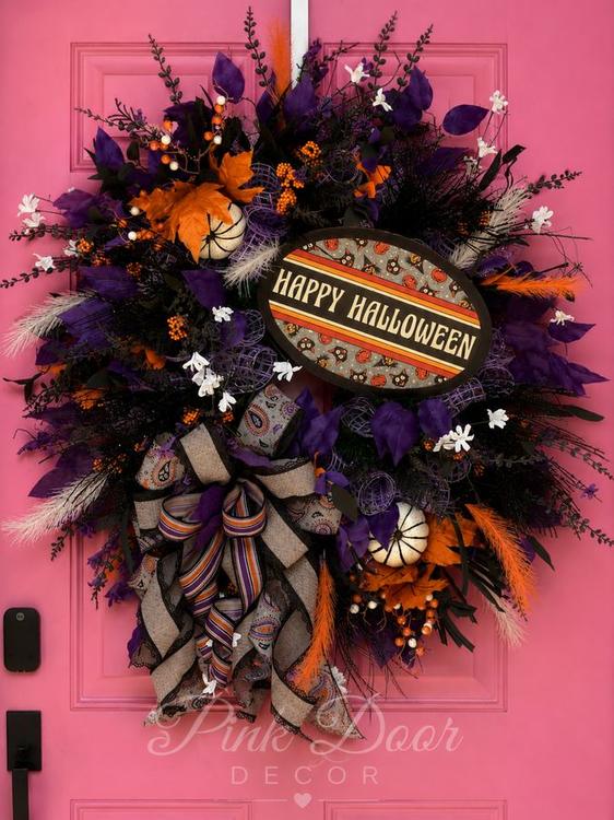 Purple and orange vintage Happy Halloween wreath on the pink door