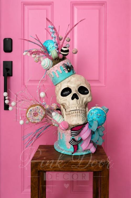 Skull centerpiece topped with pastel candy drip cake and donuts