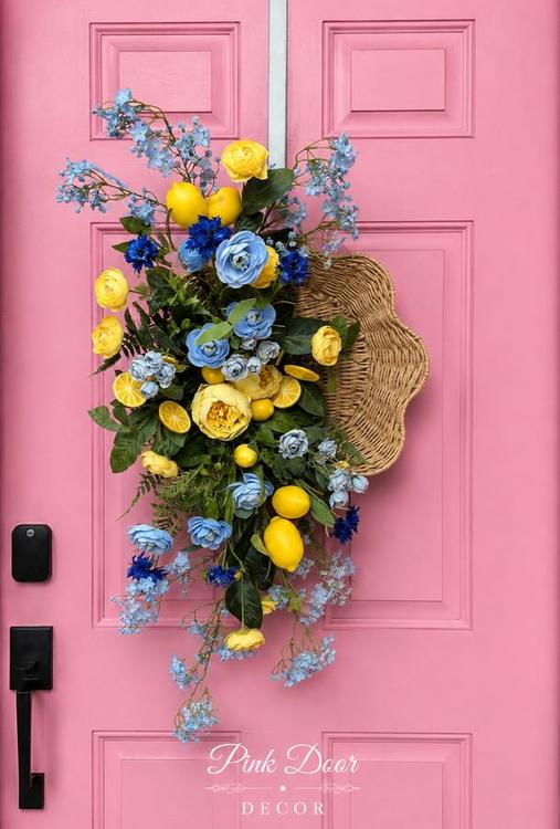 Scalloped wicker basket with lemons and blue and yellow florals on the pink door