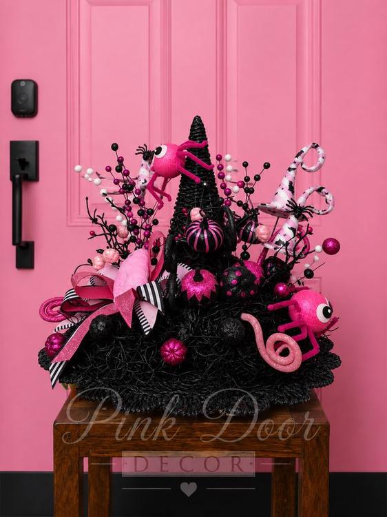 Black witch hat centerpiece with hot pink spiders and pumpkins